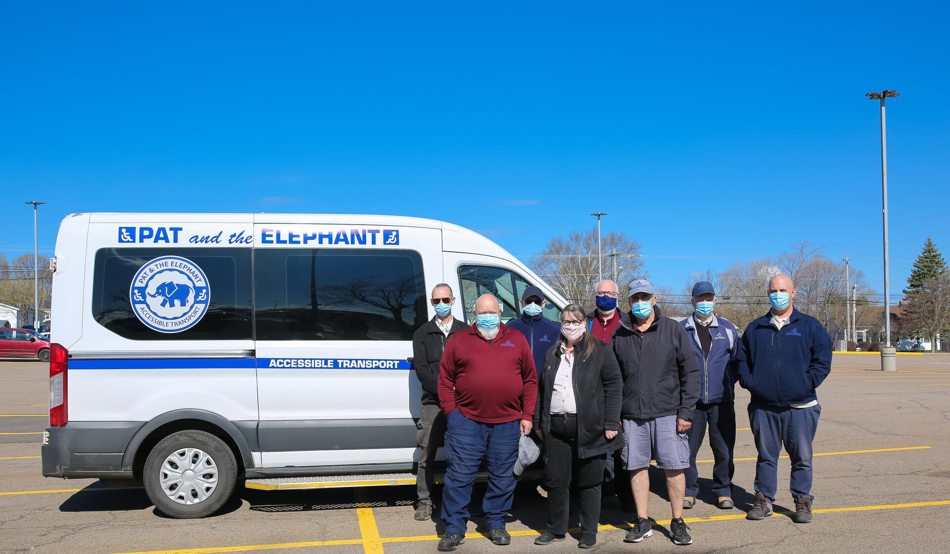 Pat & The Elephant accessible wheelchair van on a PEI road, daytime, bright sky, white vehicle with navy lettering